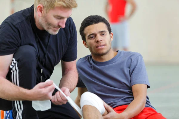运动员运动事故后按摩脚踝受伤 — 图库照片