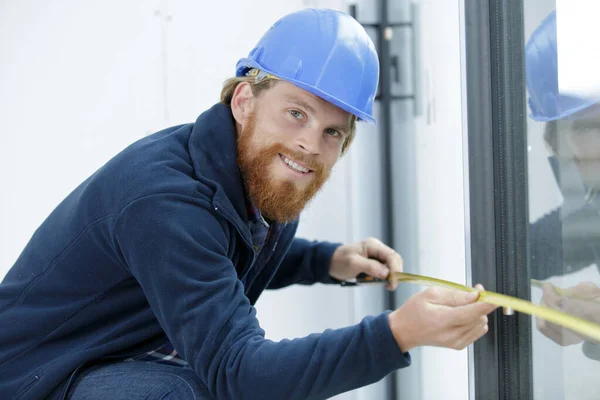 portrait of workman measuring patio doors