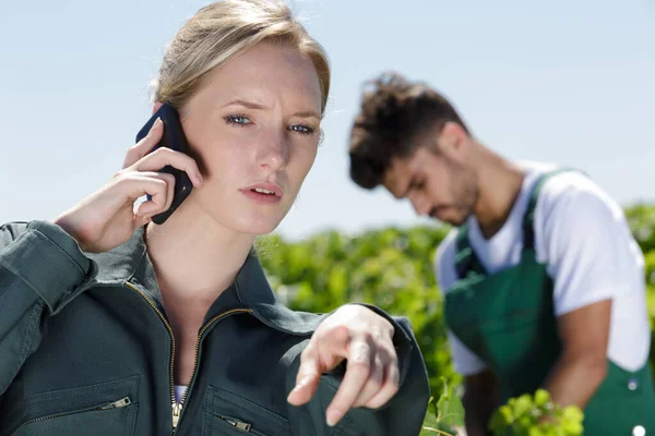 Kadın Çiftçi Işaret Ederken Telefonla Konuşuyor — Stok fotoğraf