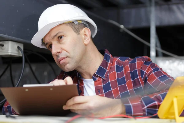 Man Builder Holds Clipboard Pen —  Fotos de Stock