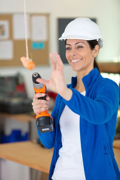 Female Builder Trying Catch Dangling Carrot — Stock Photo, Image