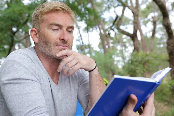 Man Reading His Survival Notebook Wood — Foto Stock