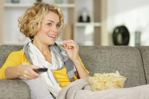Junge Glückliche Frau Isst Chips Während Sie Fernsieht — Stockfoto