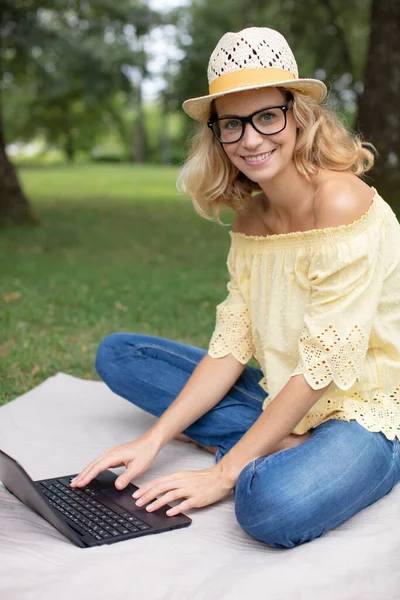 Όμορφο Κορίτσι Που Εργάζεται Ένα Φορητό Υπολογιστή Κάθεται Στο Πράσινο — Φωτογραφία Αρχείου