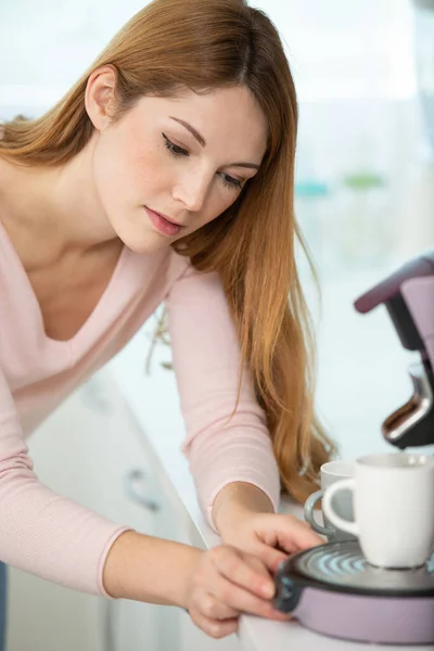 portrait of beautiful  woman making coffee in her kitchen