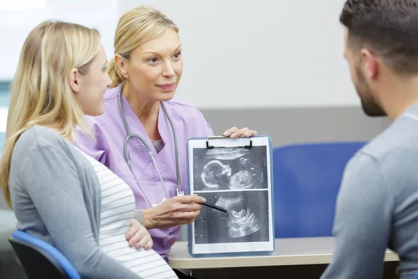 Γυναίκα Γιατρός Δείχνει Αποτελέσματα Των Ακτινών Έγκυο Ζευγάρι — Φωτογραφία Αρχείου