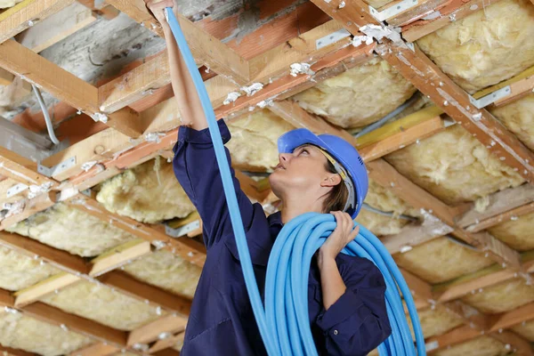 建筑物天花板安装空调管的女电工 — 图库照片