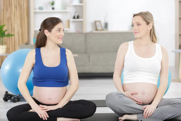 两个漂亮的怀孕的年轻瑜伽模特在室内锻炼 — 图库照片