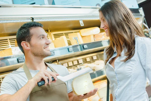 售货员问顾客在哪里切一大块奶酪 — 图库照片