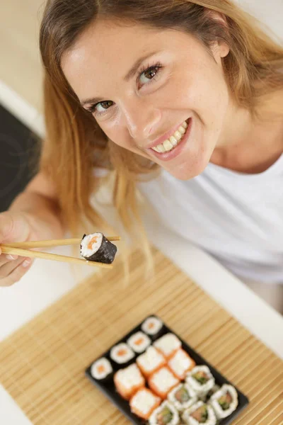 Foto Mulher Comendo Sushi Com Pauzinhos — Fotografia de Stock