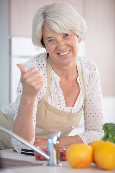 Ηλικιωμένη Γυναίκα Ποδιά Μαγειρεύει Στο Σπίτι — Φωτογραφία Αρχείου