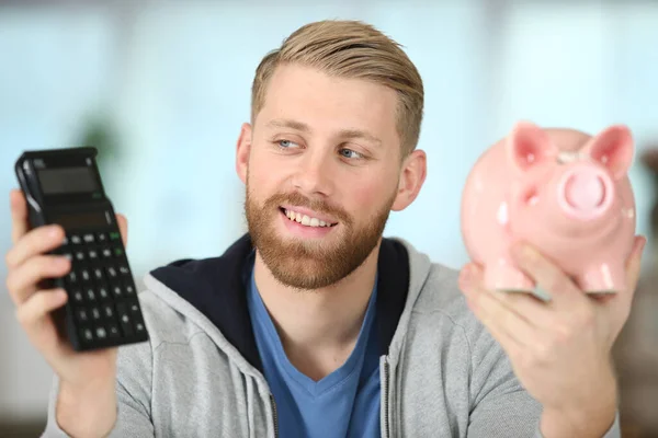 Happy Young Man Piggy Bank Calculator — Stock Photo, Image
