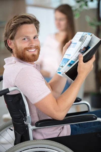 車椅子の男が雑誌を読んでいて — ストック写真