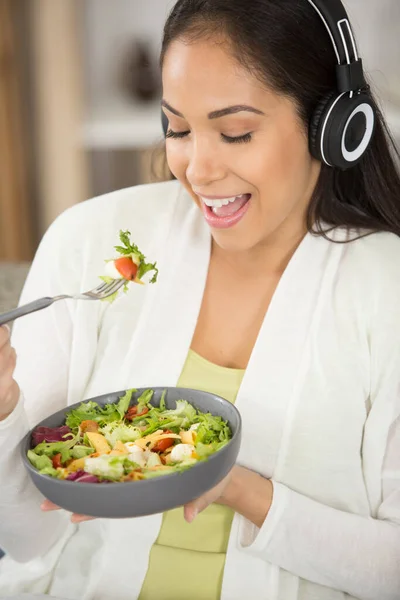 Χαρούμενη Γυναίκα Που Φοράει Ακουστικά Ενώ Τρώει Γεύμα Της — Φωτογραφία Αρχείου