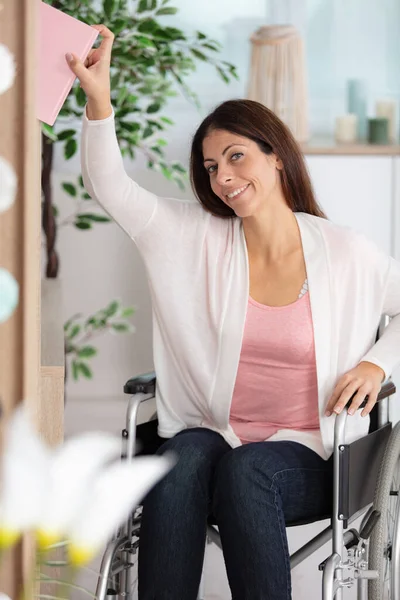 Usmívající Žena Invalidním Vozíku Sahá Knize — Stock fotografie