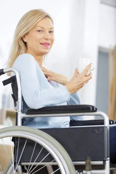 Szczęśliwa Kobieta Wózku Inwalidzkim Trzyma Filiżankę Kawy — Zdjęcie stockowe