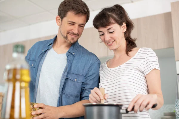 一对快乐的年轻夫妇在厨房里一起做饭的肖像 — 图库照片