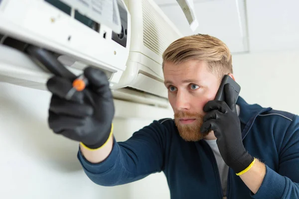 男技术员在室外修理冷气机 — 图库照片