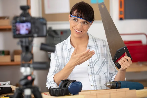 Kobieta Budowniczy Wideo Blogger Pokazując Piłę Ręczną — Zdjęcie stockowe