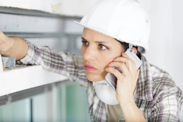 Concerned Female Builder Using Smartphone — Stock Photo, Image
