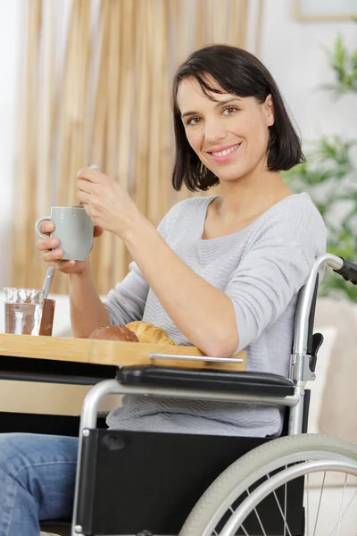 車椅子の幸せな女性が朝食を取り — ストック写真