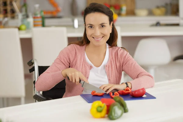 handicapped woman cutting vegetables smiling