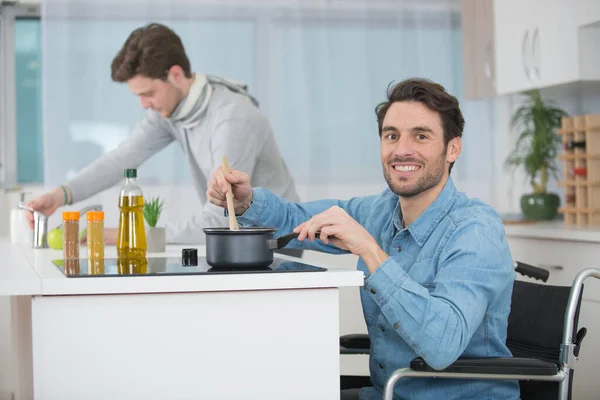坐在轮椅上的男人在厨房做饭 — 图库照片
