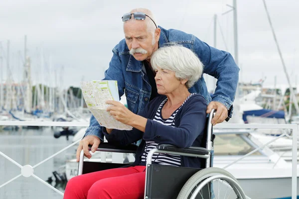 handicapped woman in wheelchair with husband looking at a map