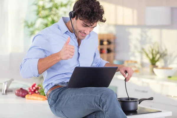 Adam Yemek Pişiriyor Kulaklık Takıyor Laptop Kullanıyor — Stok fotoğraf