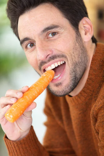 Junger Mann Ißt Eine Karotte — Stockfoto