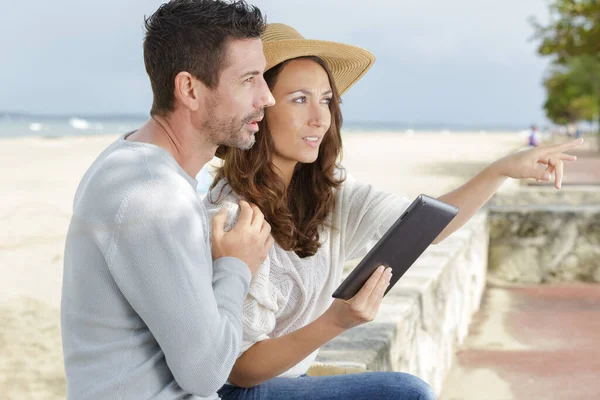 Ζευγάρι Που Χαλαρώνει Στην Παραλία Και Χρησιμοποιεί Ψηφιακό Tablet — Φωτογραφία Αρχείου