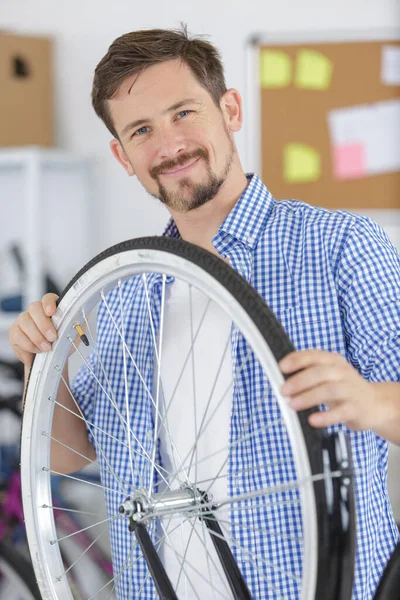 Man Leende Mästare Håller Ett Cykelhjul — Stockfoto