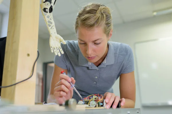若い女性技術者が機械を作りながら — ストック写真