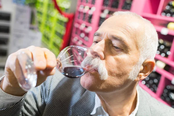 Uśmiechnięty Starszy Mężczyzna Tatuujący Wino Supermarkecie — Zdjęcie stockowe