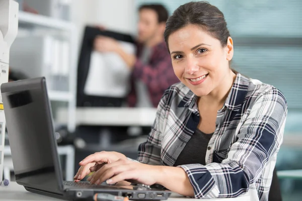 快乐女性技师使用笔记本电脑分析服务器 — 图库照片