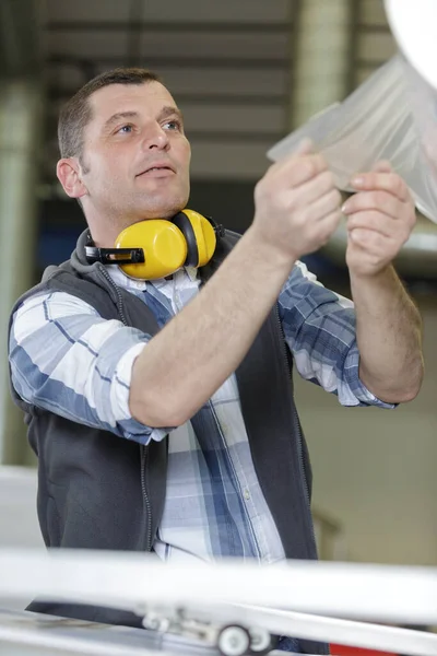 Male Factory Worker Pulling Length Plastic Film — Stock Photo, Image