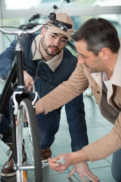 スパナーで自転車の車輪を固定する男 — ストック写真