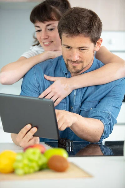 Birbirine Aşık Çiftler Mutfakta Sarılıp Tablet Kullanıyorlar — Stok fotoğraf