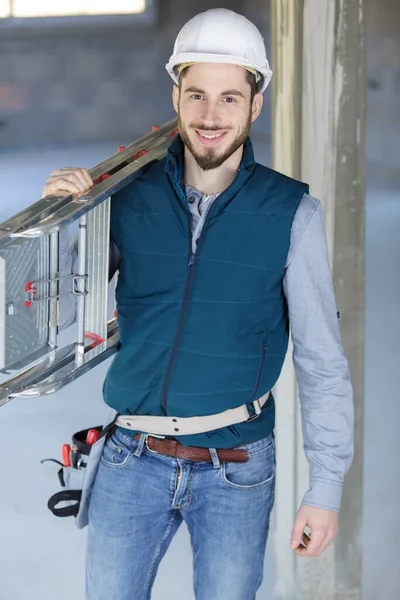 Homme Constructeur Joyeux Portant Échelle Intérieur — Photo
