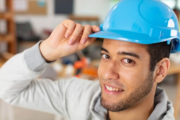 若い建設労働者は硬い帽子をかぶって — ストック写真