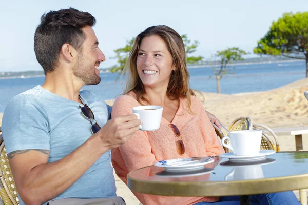 男人和女人在海边喝咖啡 — 图库照片