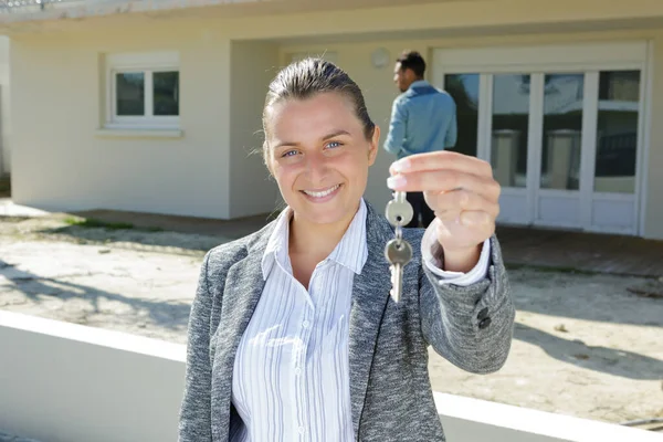 Mladá Žena Drží Klíč Poblíž Domu — Stock fotografie