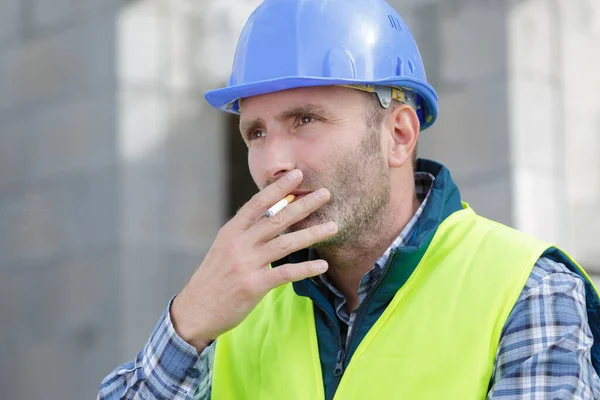 タバコを吸う男性ビルダーは — ストック写真