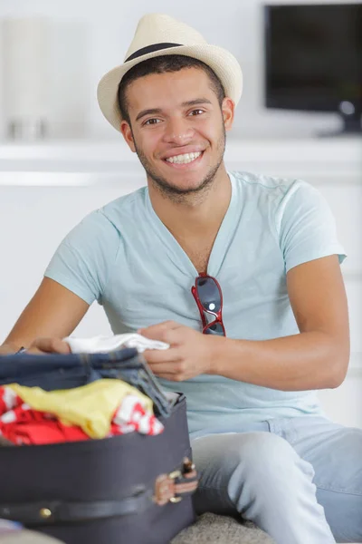 若い男を自宅にスーツケースをパッキング — ストック写真