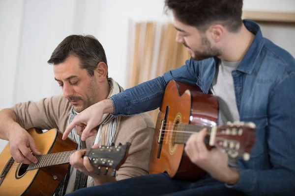 Adulto Masculino Está Ensinando Seu Filho Tocando Guitarra — Fotografia de Stock