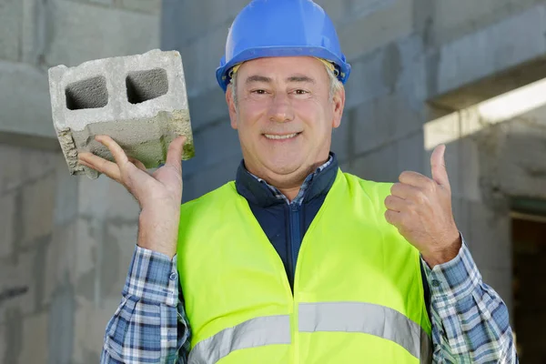 Man Builder Holding Brick Outdoors — Stock Photo, Image