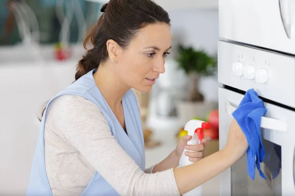 Genç Kadın Mutfakta Paçavrayla Fırını Temizliyor — Stok fotoğraf