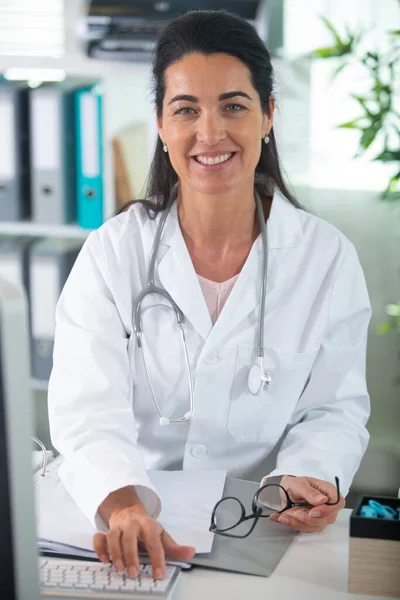 Selbstbewusste Ärztin Sitzt Schreibtisch Und Lächelt — Stockfoto
