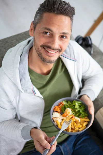Mann Isst Salat Auf Dem Sofa — Stockfoto