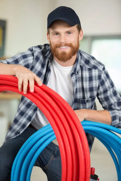 Construction Worker Happily Holding Pipes — Stock Photo, Image
